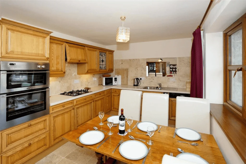 Modern kitchen interior with wooden cabinets and dining setup