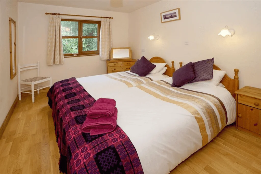 Cozy bedroom with large bed and wooden furniture