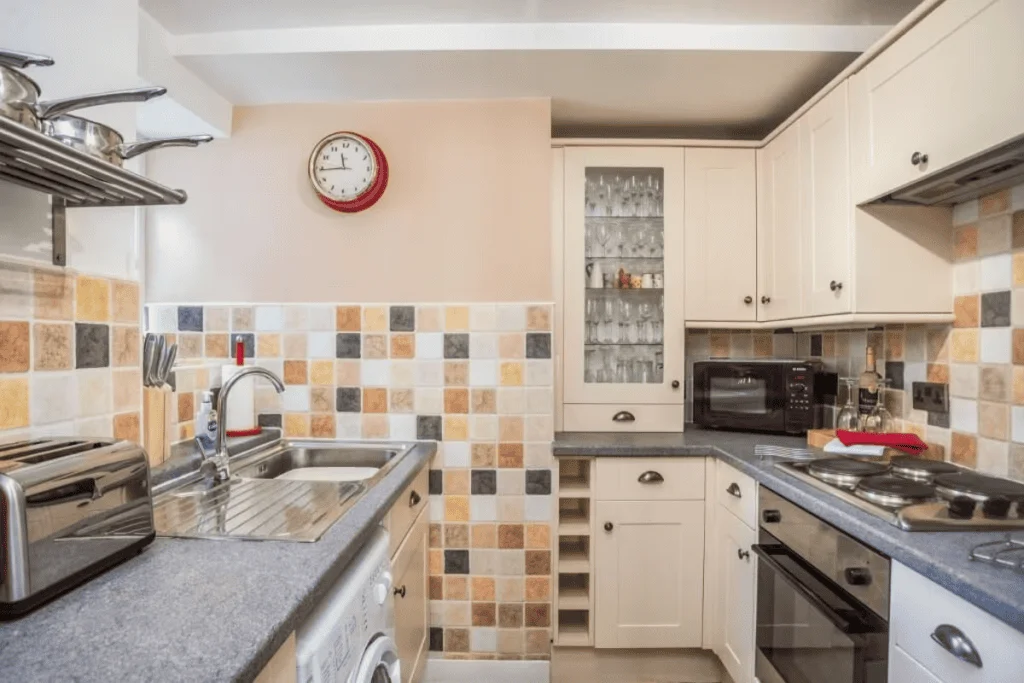 Modern kitchen with beige cabinetry and tiled backsplash