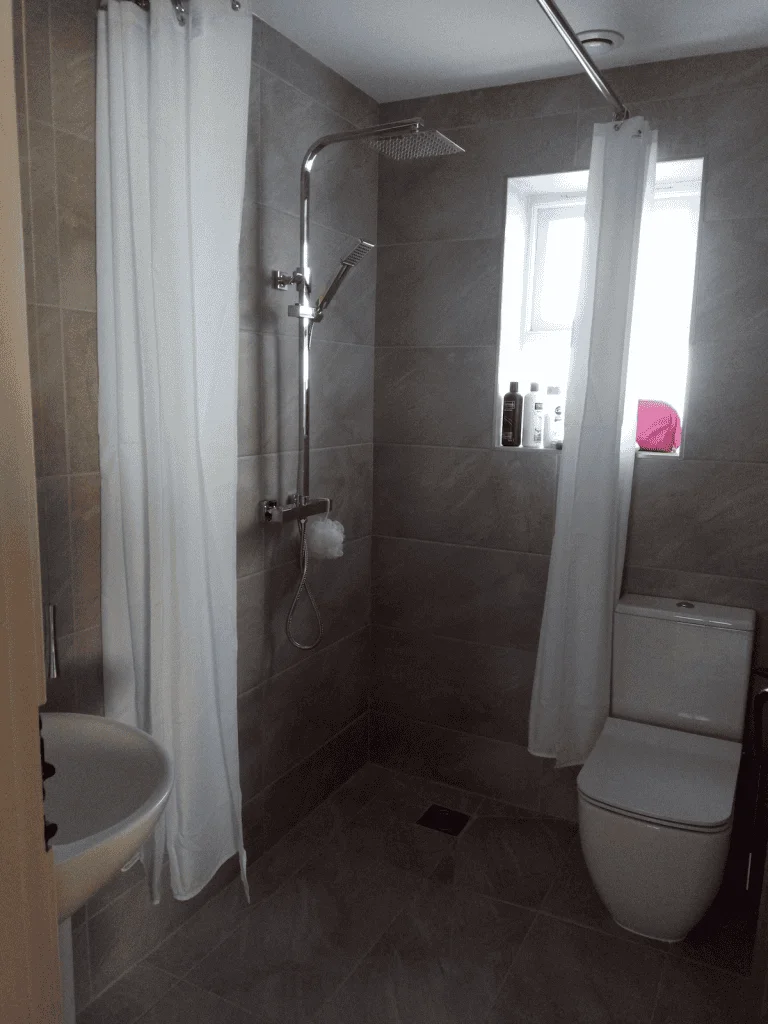 Modern bathroom with shower and gray tiles