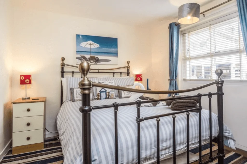 Cozy bedroom with beach-themed decor and metal bedframe