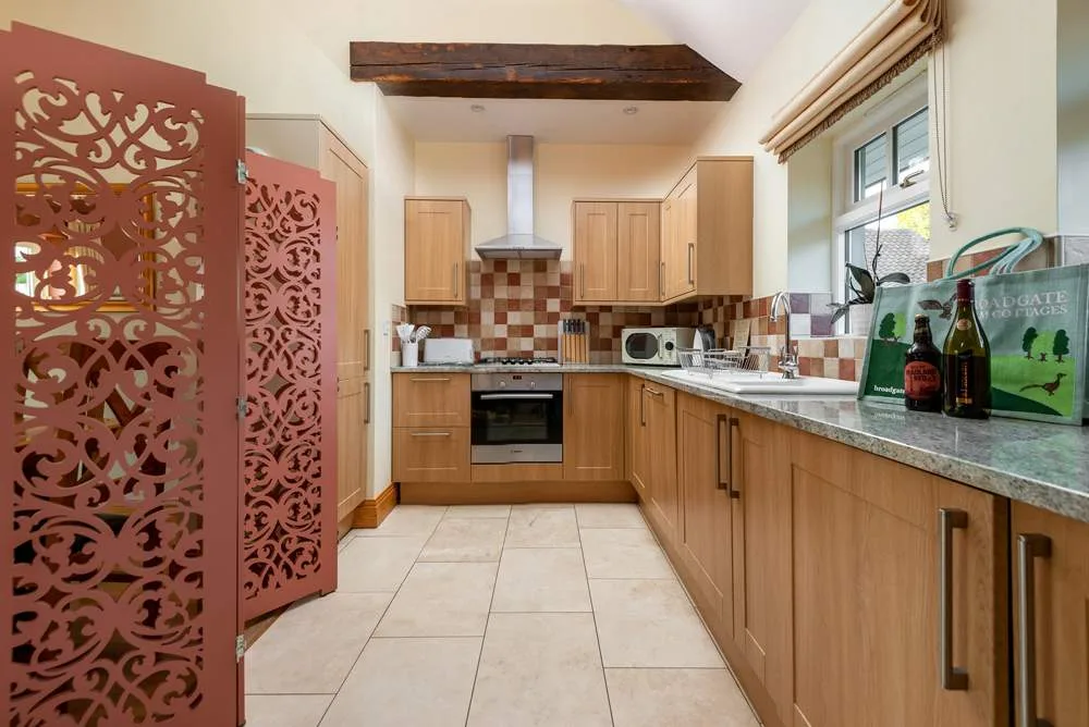 Bright kitchen with wooden cabinets and decorative pink door