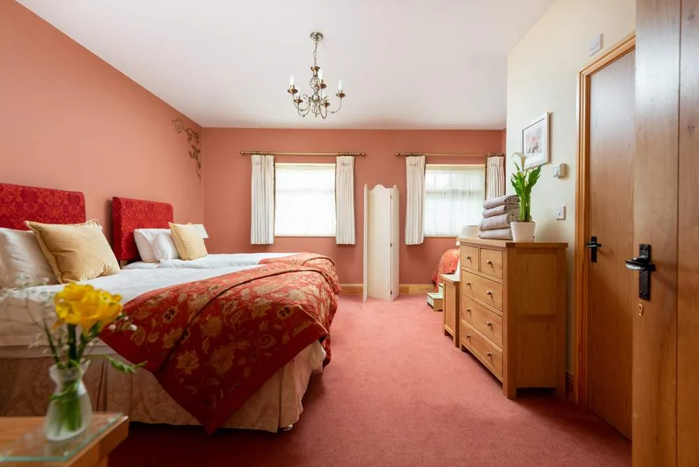 Cozy bedroom with red bedding and wooden furniture