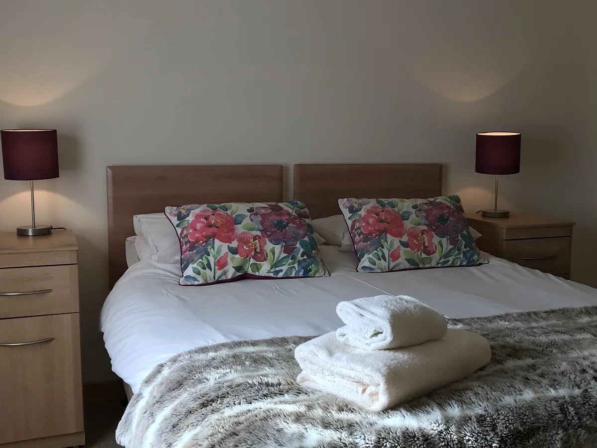 Cozy bedroom with floral pillows and warm lighting