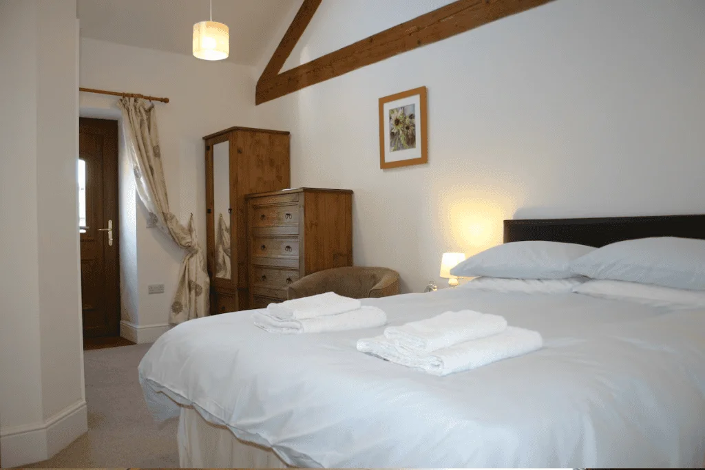 Cozy bedroom with wooden furniture and white bedding