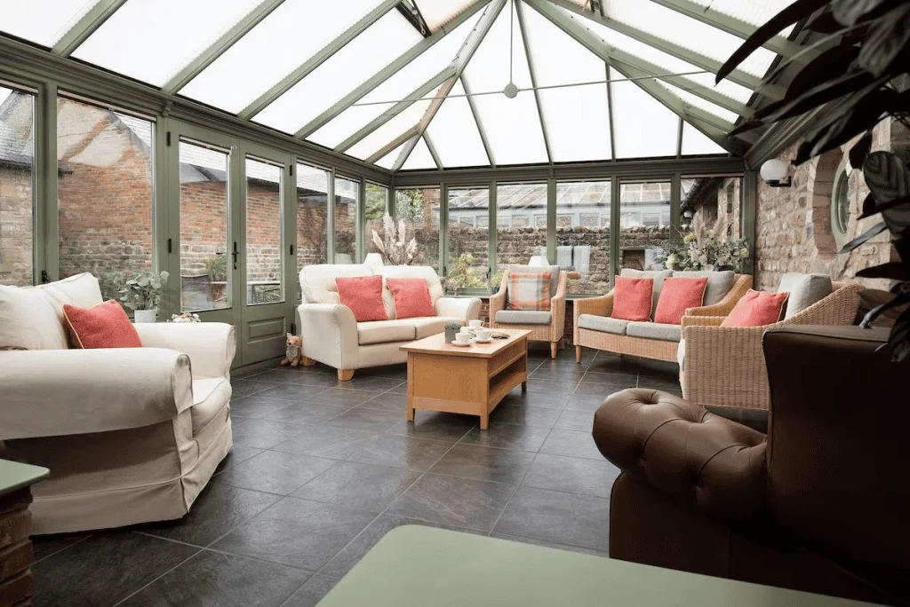 Cozy sunroom with wicker furniture and glass ceiling