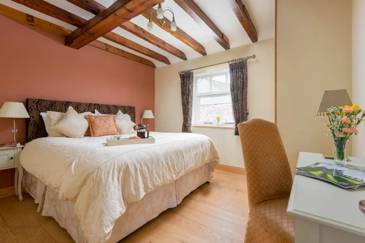 Cozy bedroom with exposed wooden beams and plush bedding