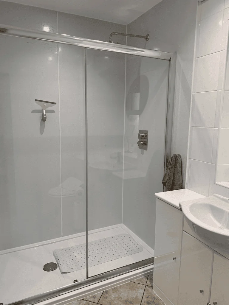 Modern bathroom with glass shower enclosure and white tiles