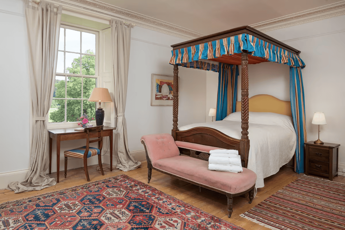 Elegant bedroom with four-poster bed and large window