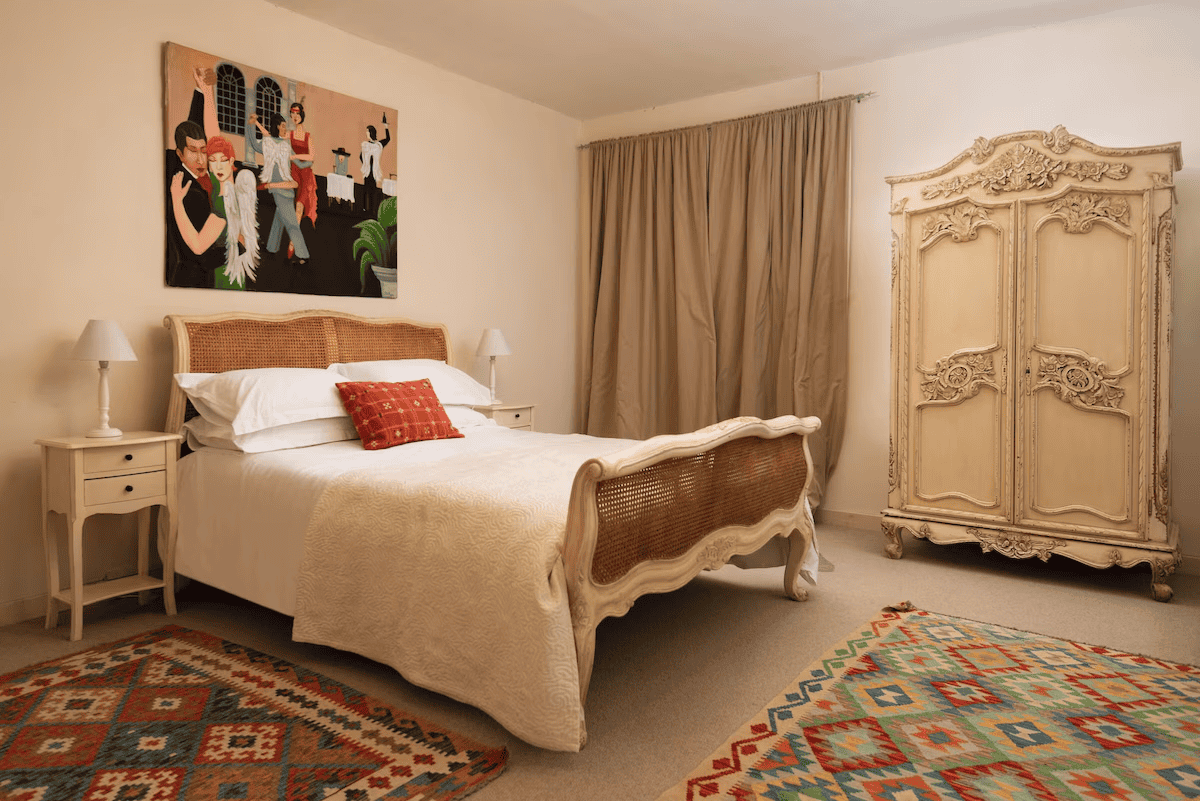 Elegant bedroom with vintage furniture and colorful rug