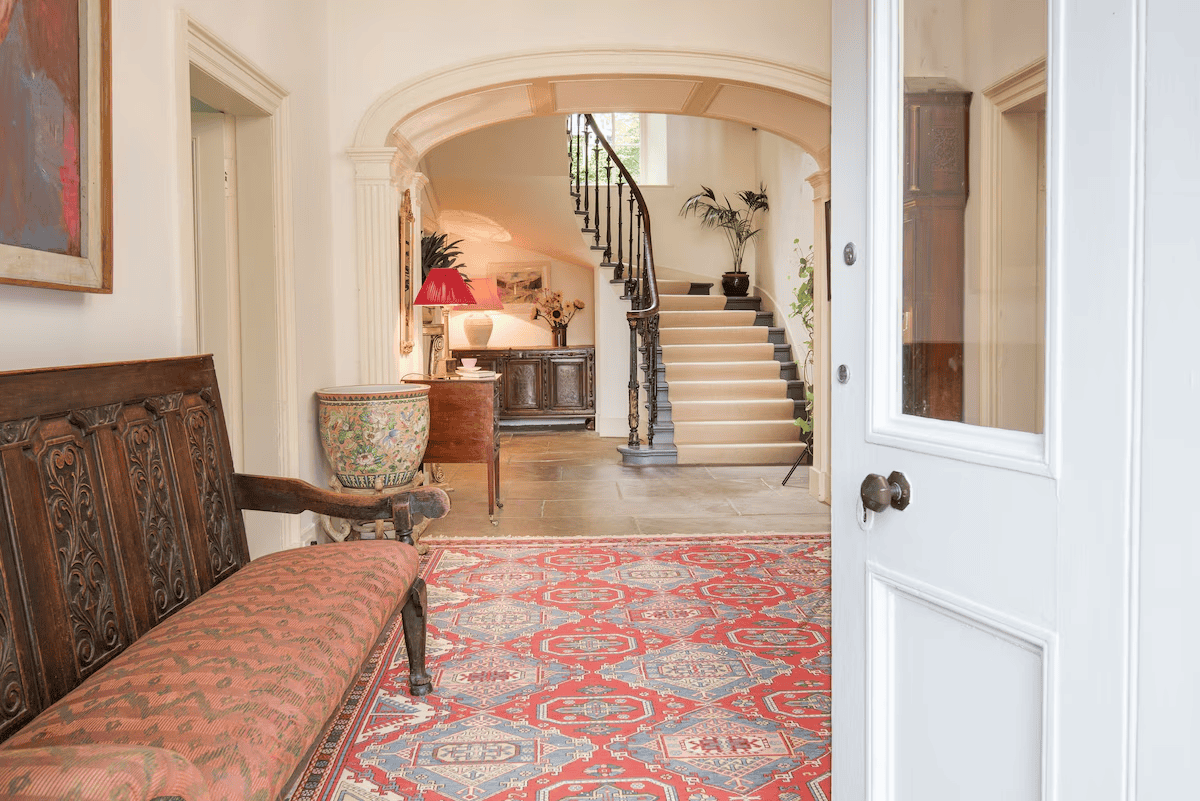 Elegant entryway with arched doorway and curved staircase