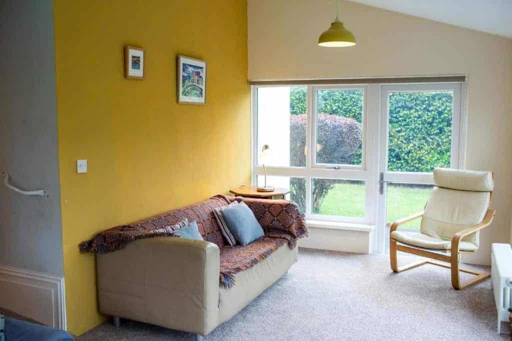 Cozy living room with yellow wall and garden view