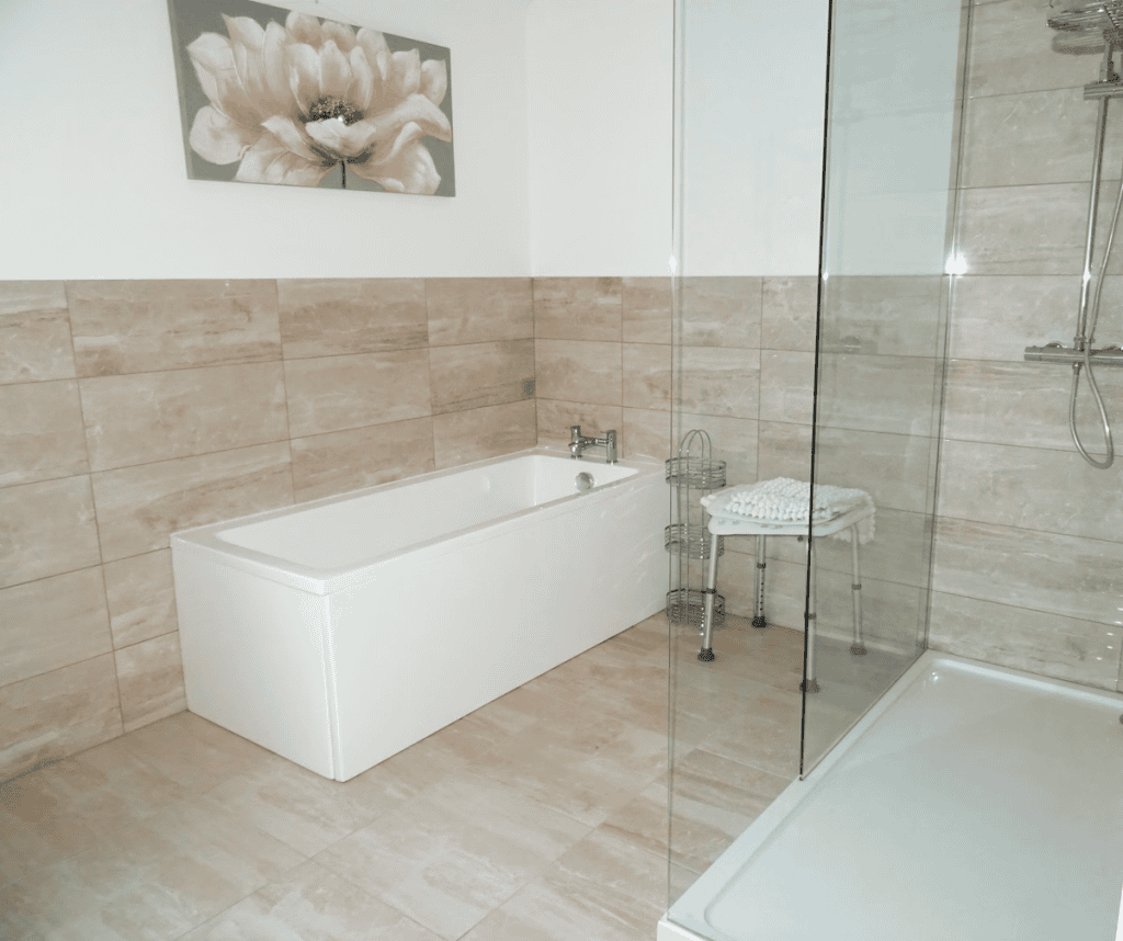 Modern bathroom with tub, shower, and floral wall art.