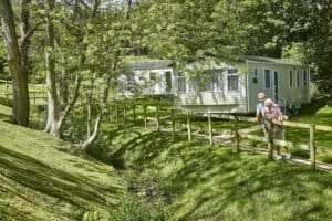 Elderly couple walking near forest cabin