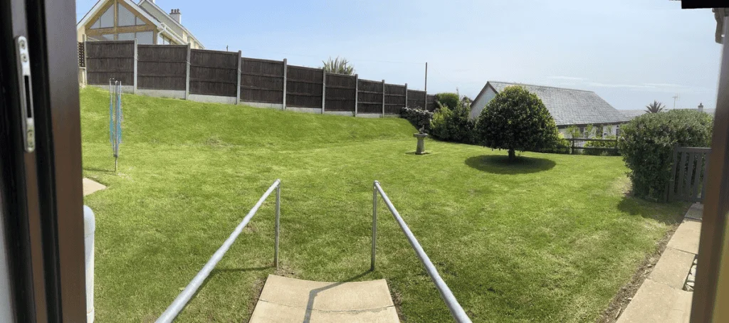 Panoramic view of a lush green backyard with houses