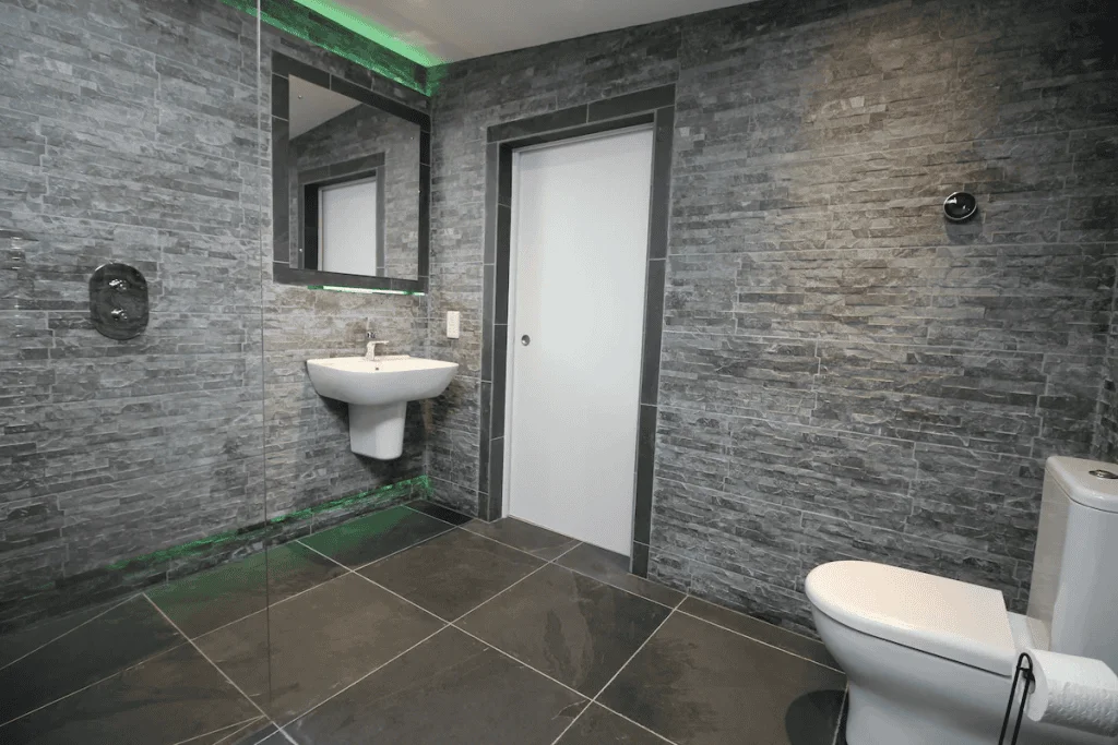 Modern bathroom with gray slate tiles and green lighting