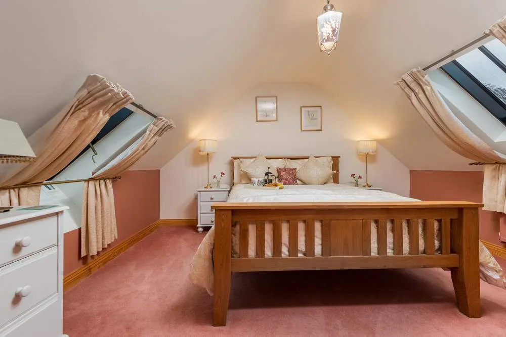 Cozy attic bedroom with skylights and wooden furnishings