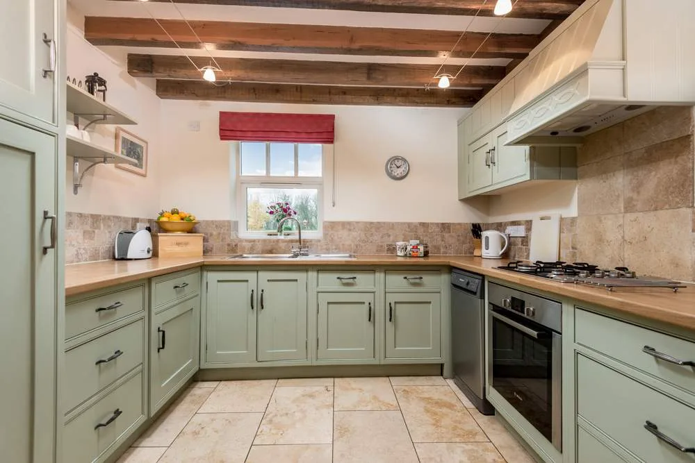 Modern kitchen with wooden beams and green cabinets