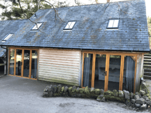 Rustic wooden cabin with slate roof and large windows