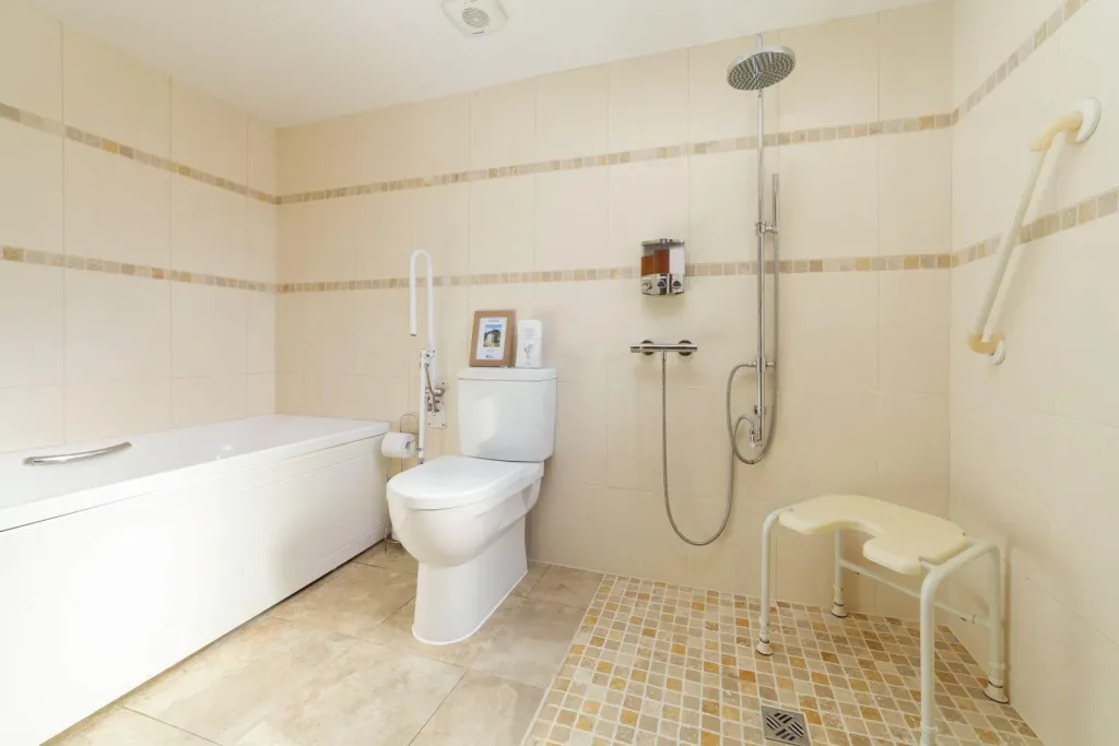 Accessible bathroom with bathtub, shower, and safety supports