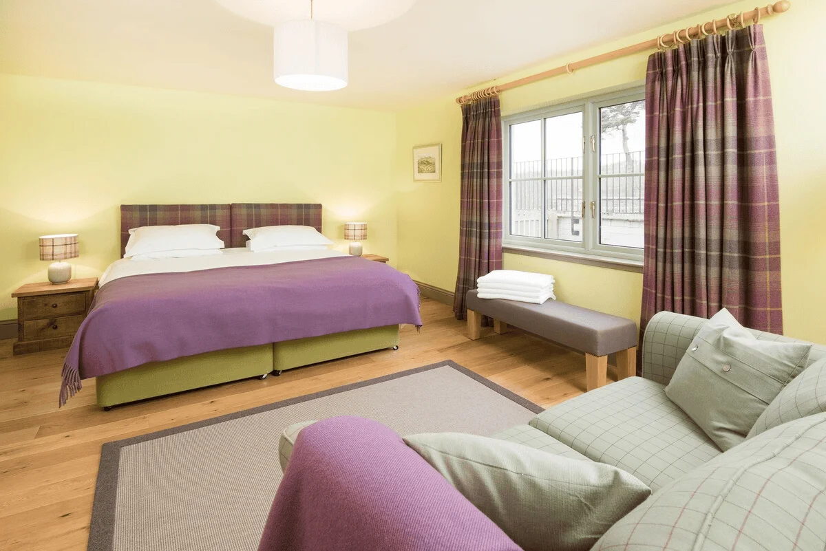 Bright cozy bedroom with large bed and sitting area