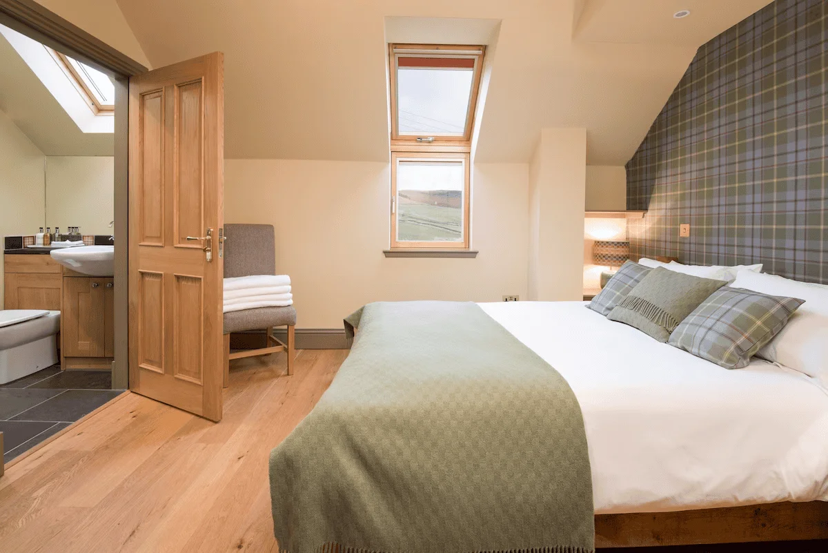 Cozy hotel room with bed, open door, and countryside view