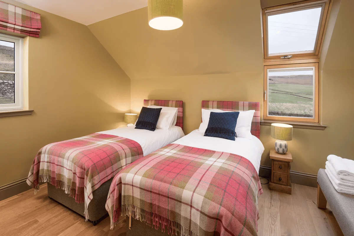 Cozy twin bedroom with plaid bedding and scenic view