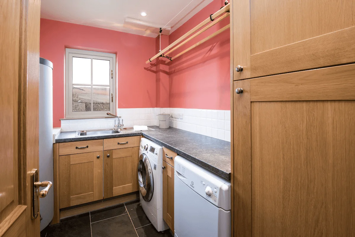 Bright kitchen with pink walls and wooden cabinets