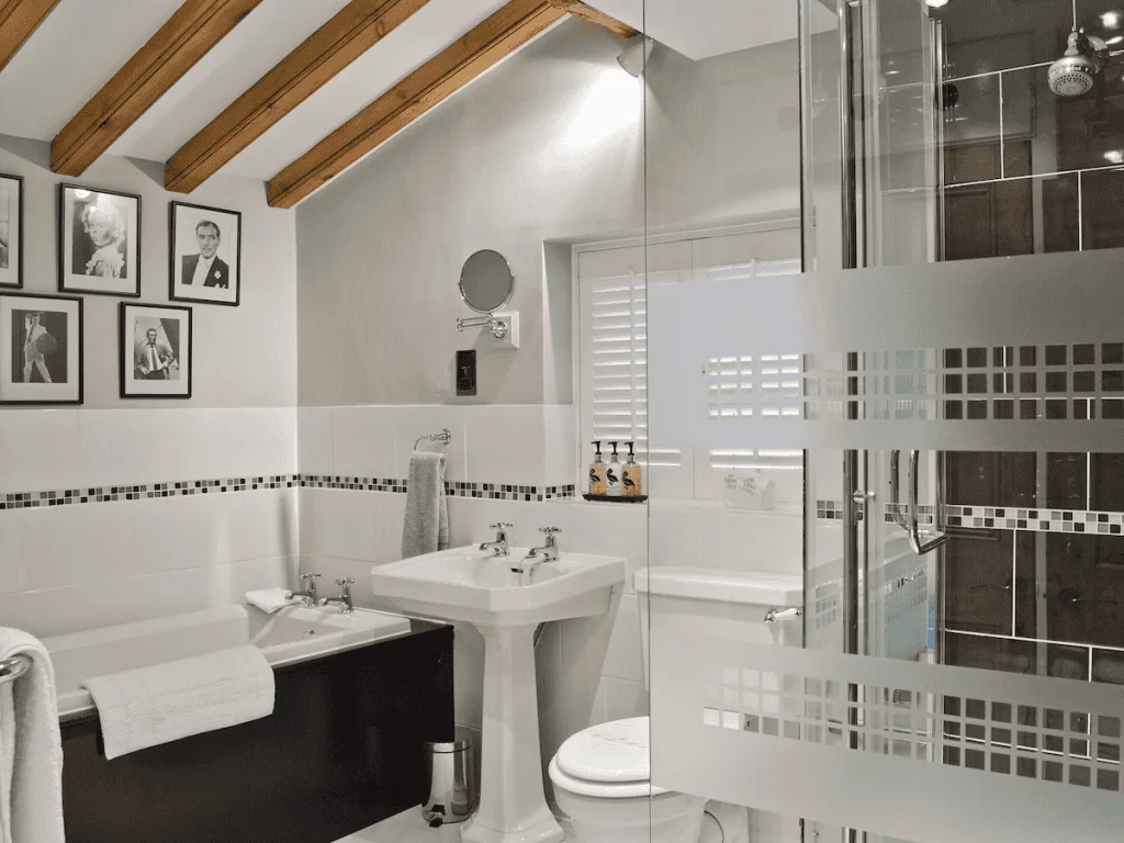 Modern bathroom with exposed beams and framed photographs