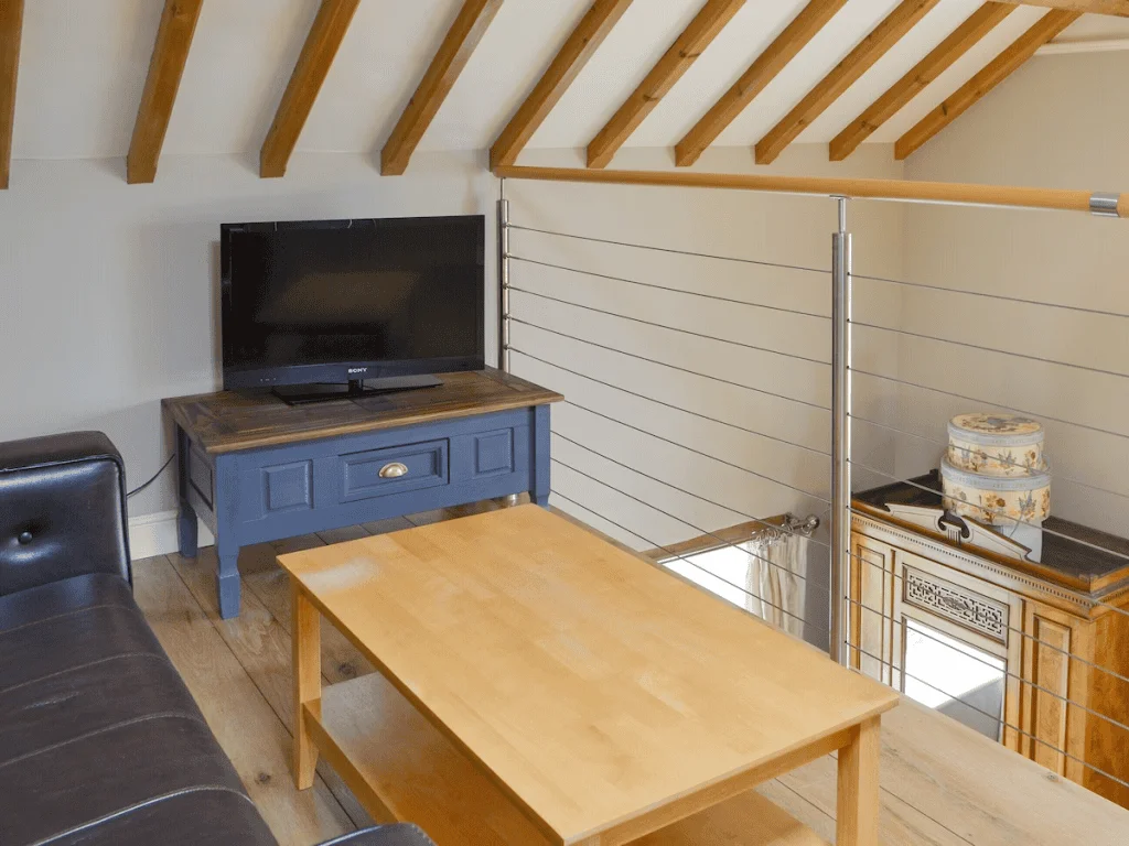 Cozy attic living room with wooden furniture and TV