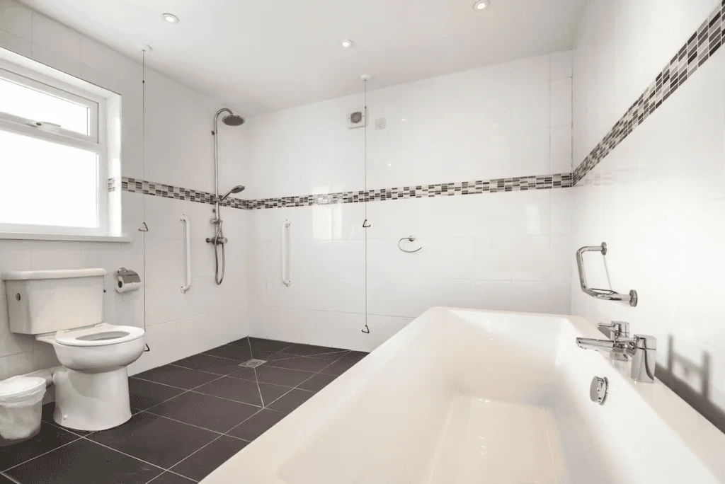 Modern bathroom with tub, shower, and tiled floor.