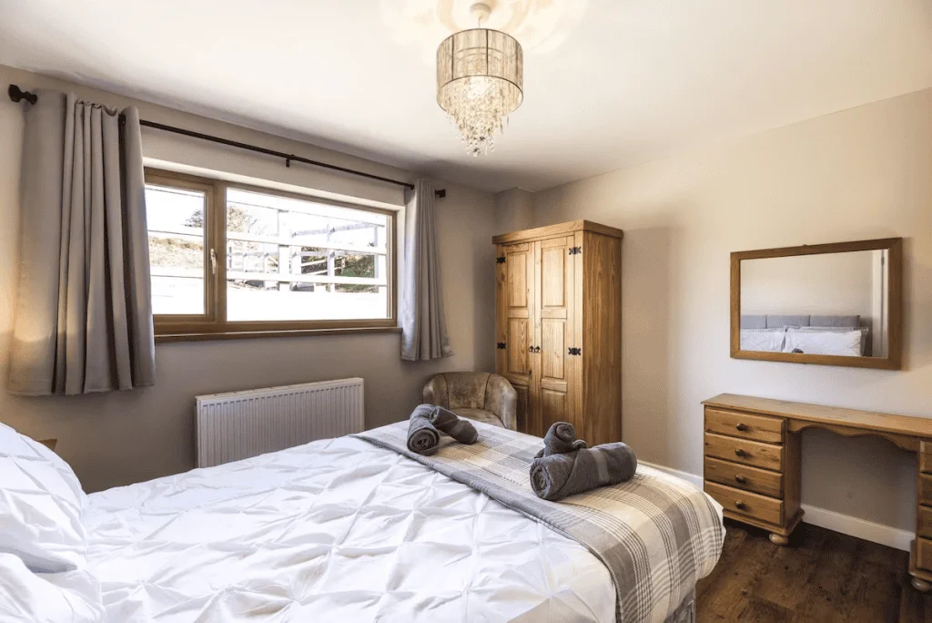 Bright cozy bedroom with elegant decor and wooden furniture