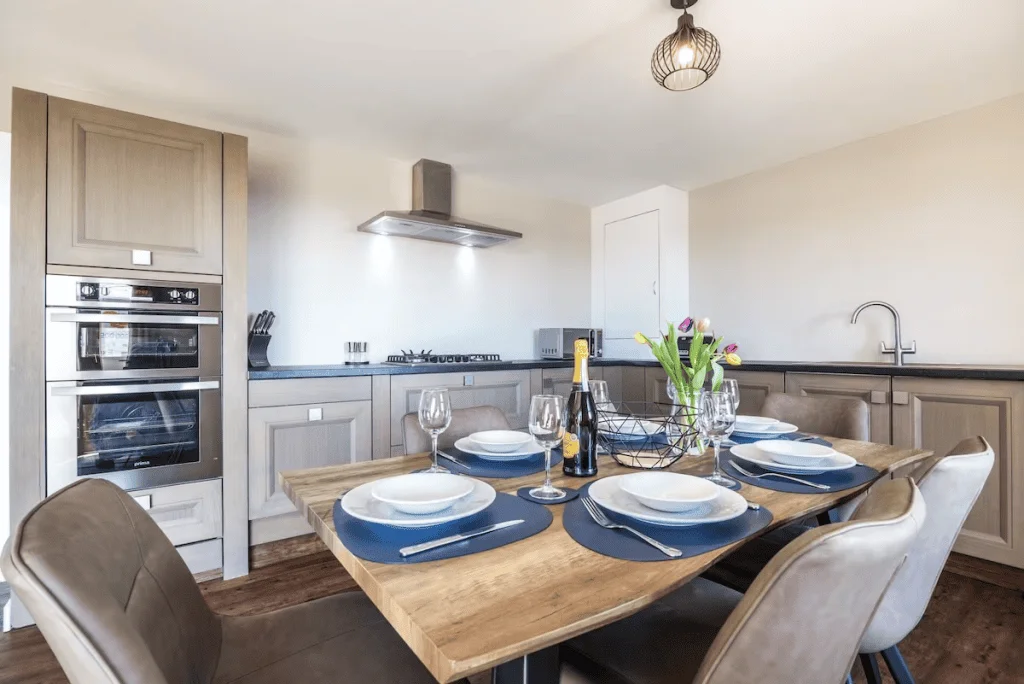 Modern kitchen with set dining table and appliances