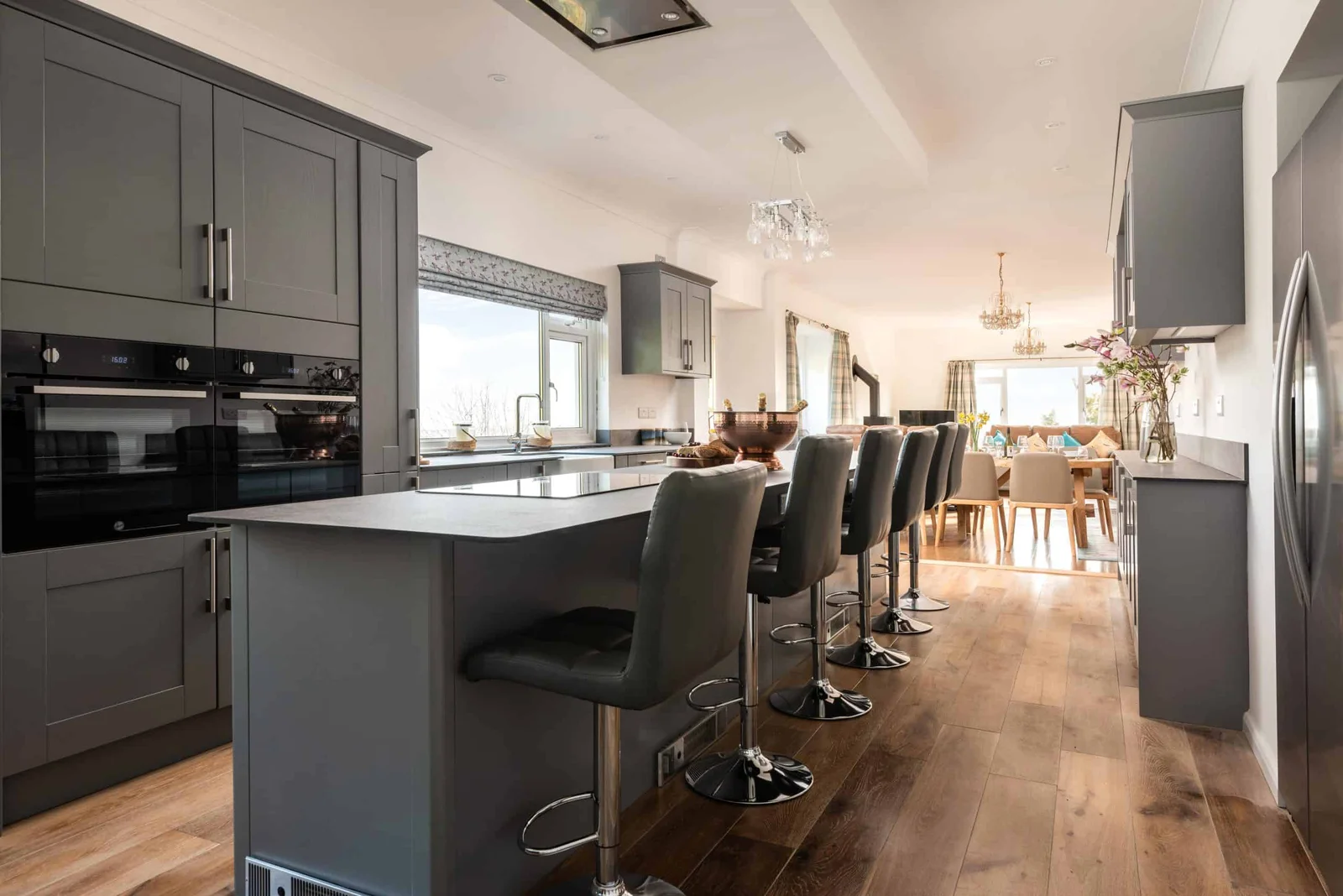 Modern kitchen with bar stools and elegant dining area