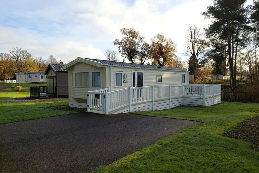 Mobile home with deck in serene park setting