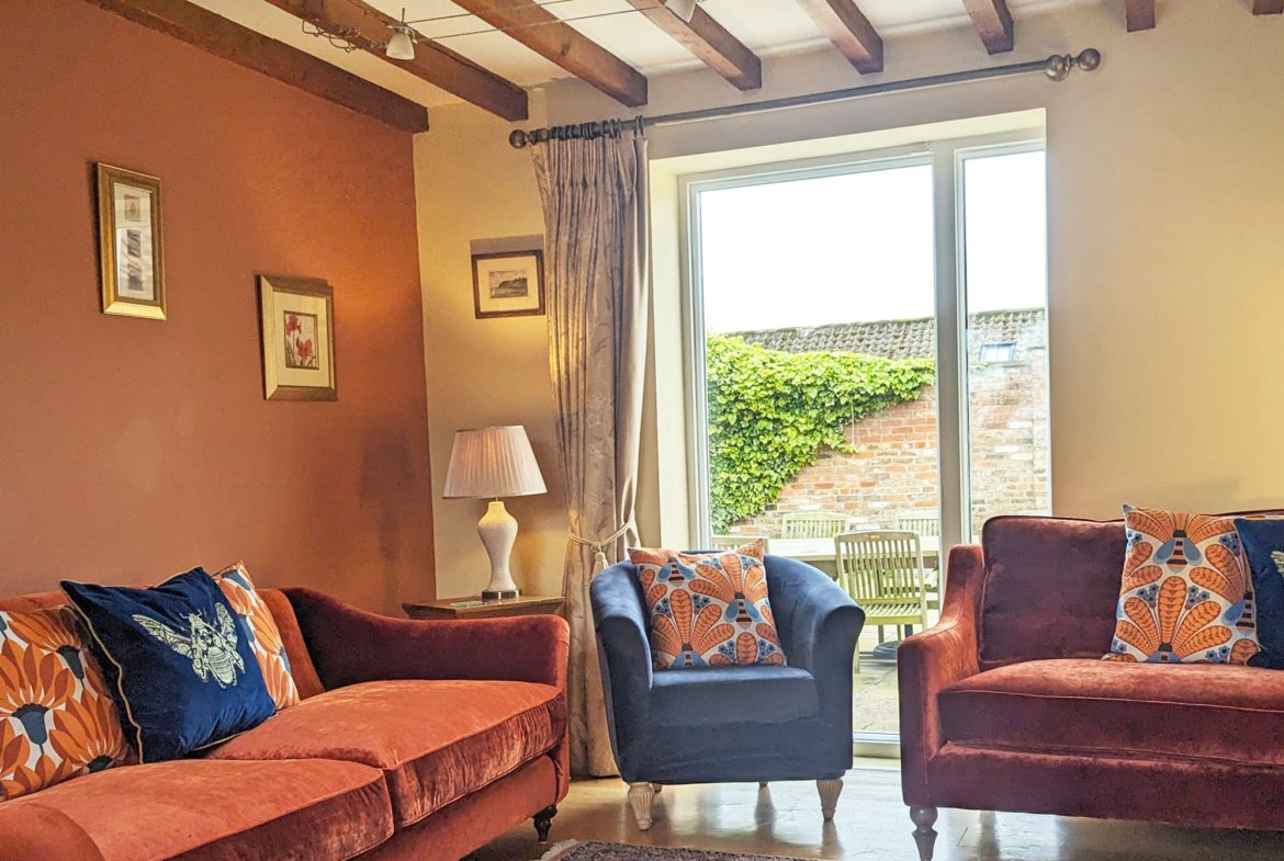 Cosy living room with colourful sofas and garden view.