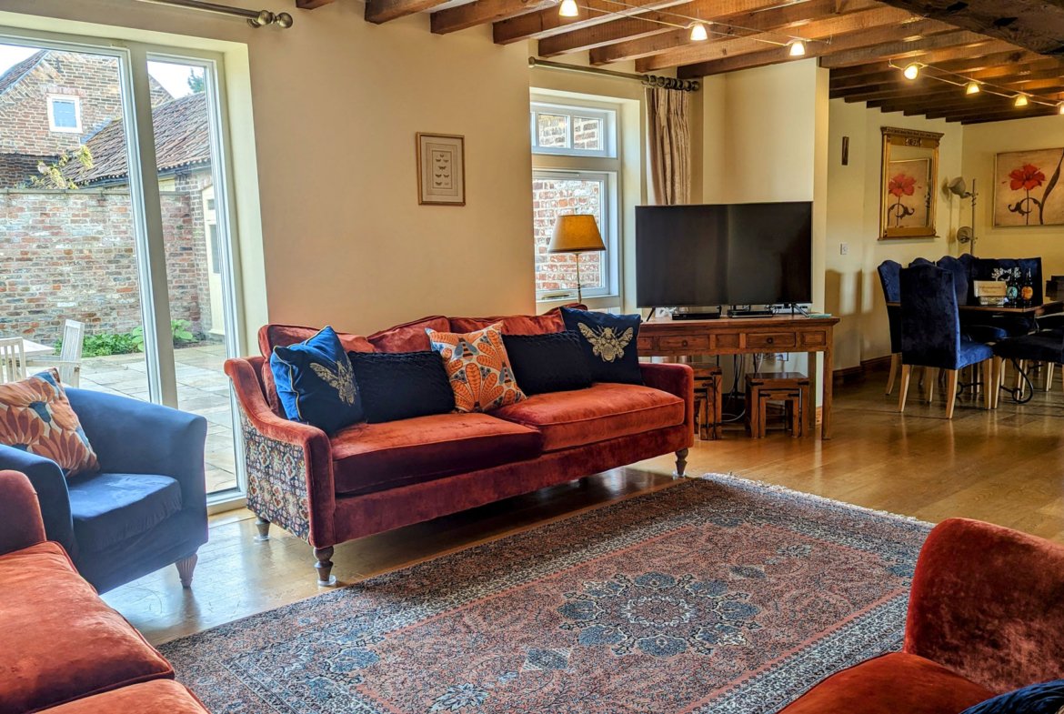Cosy living room with colourful sofas and rugs.