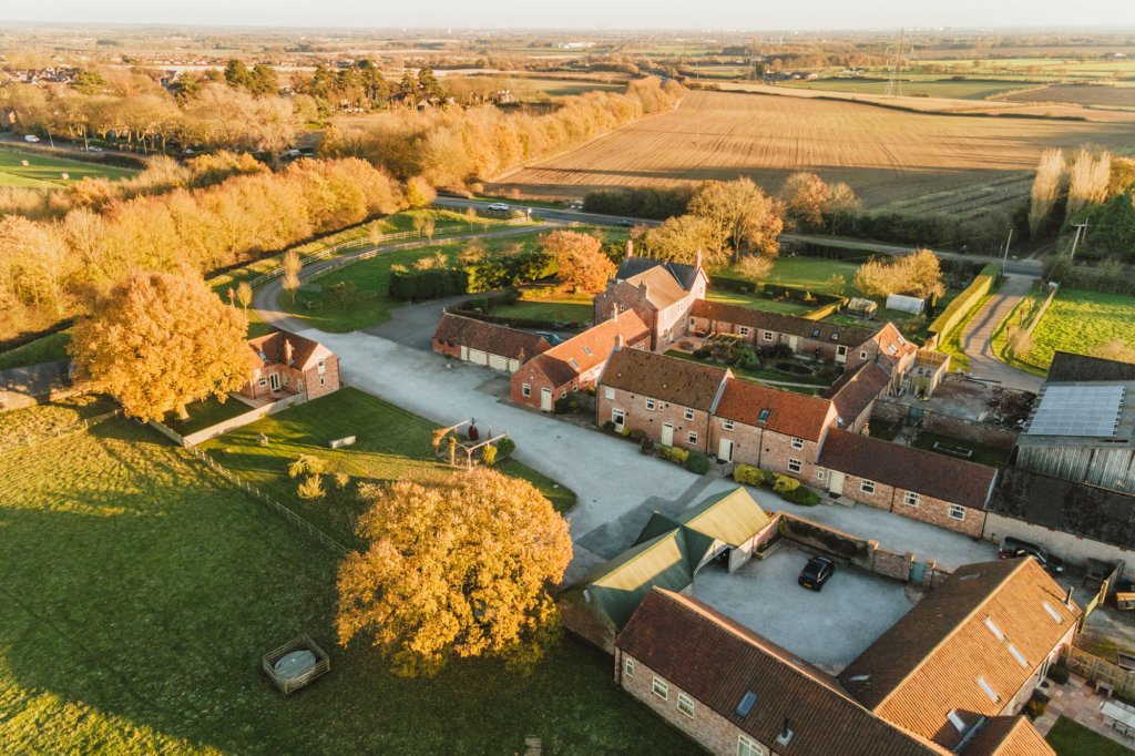 Aerial view of countryside farm buildings and fields.