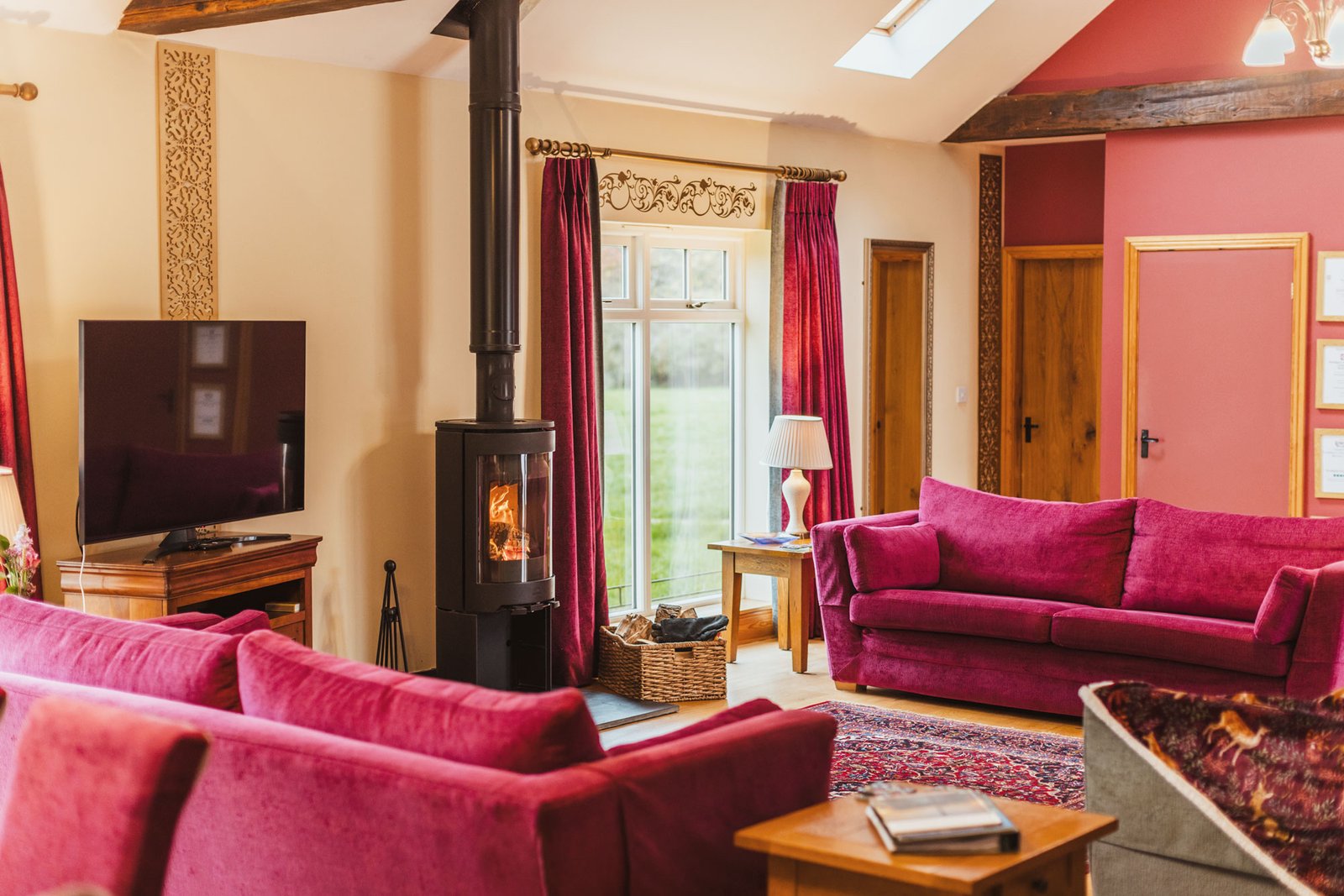 Cosy living room with fireplace and red sofas.