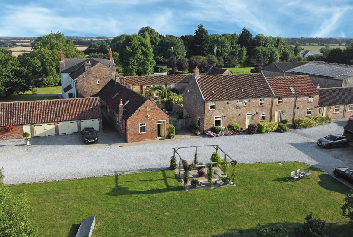Aerial view of countryside property with garden and buildings.