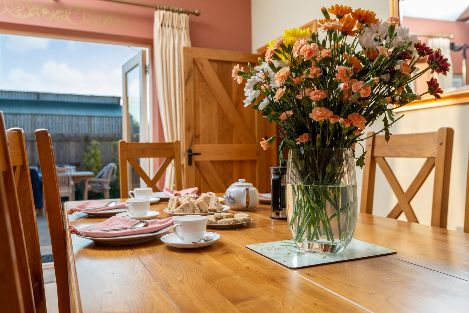 Dining table with flowers and tea set.