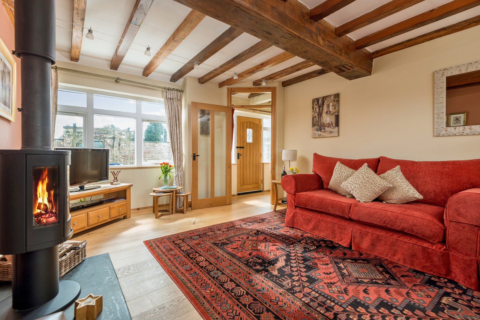 Cosy living room with fireplace and red sofa.