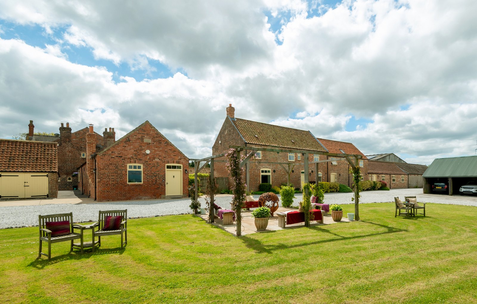 Charming countryside brick cottages under cloudy sky.