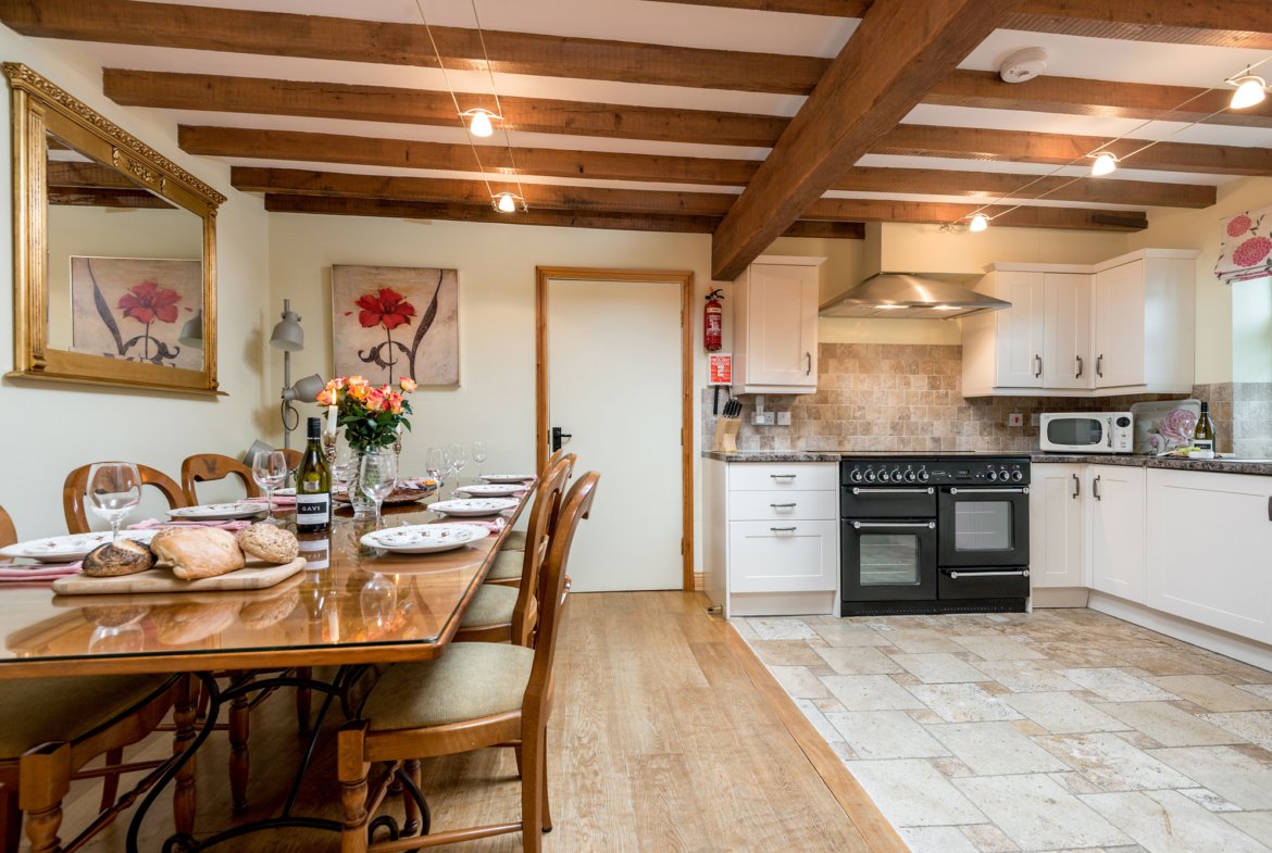 Rustic kitchen with dining table and modern appliances.