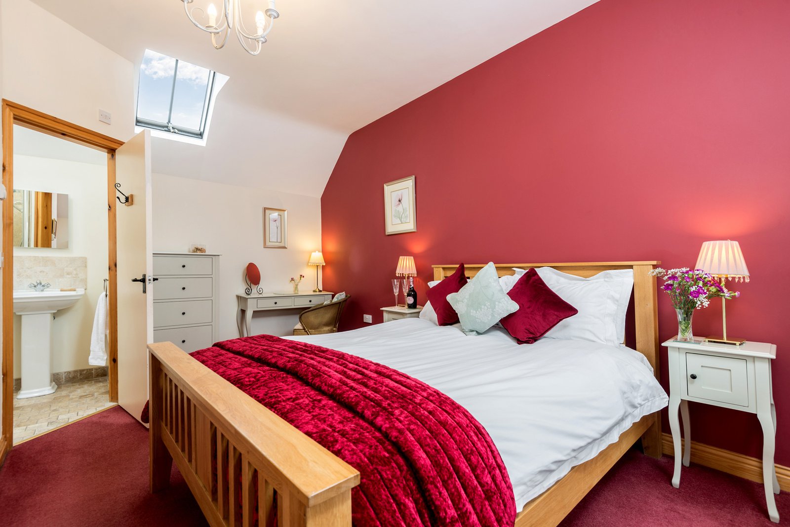 Cosy bedroom with red accents and skylight window.