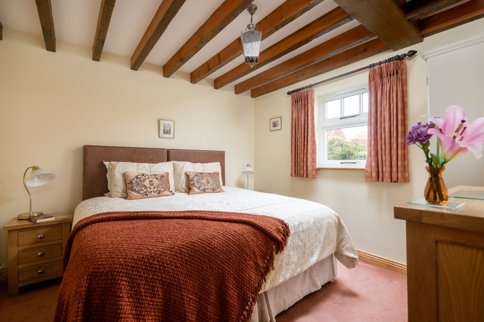 Cosy bedroom with wooden beams and large bed.
