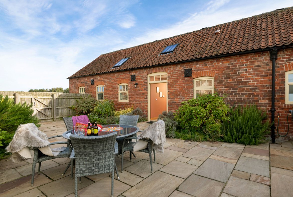 Brick cottage with patio and outdoor seating.