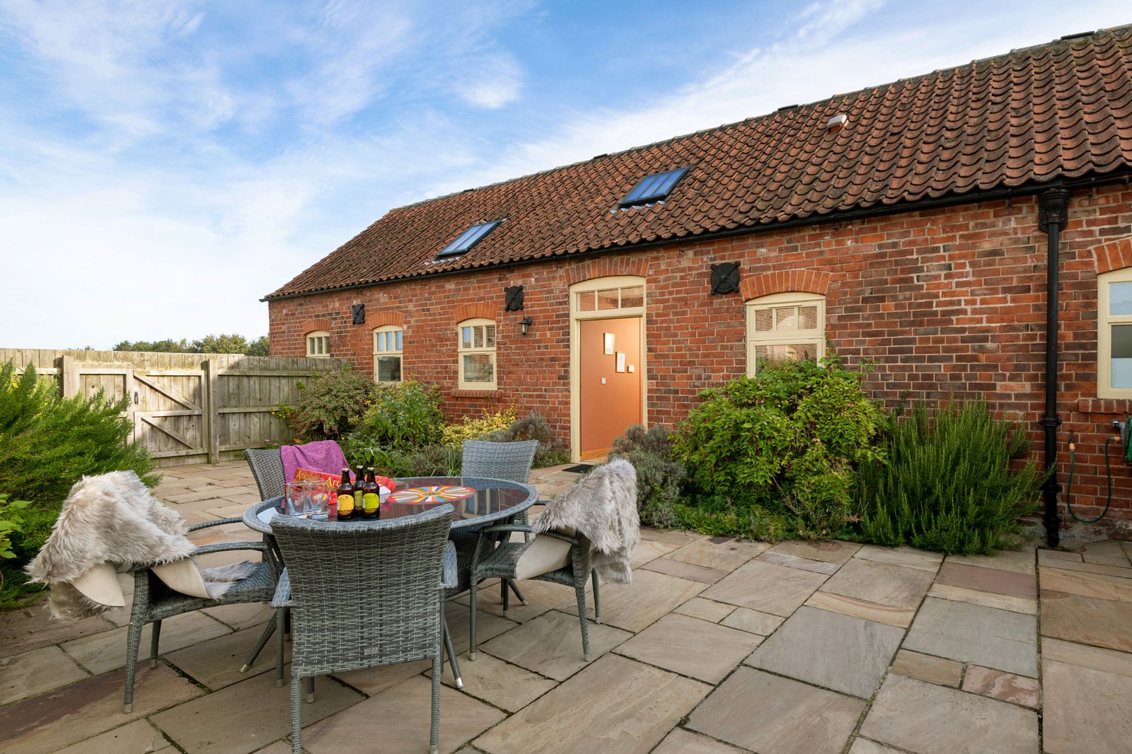 Brick cottage with patio and outdoor seating.