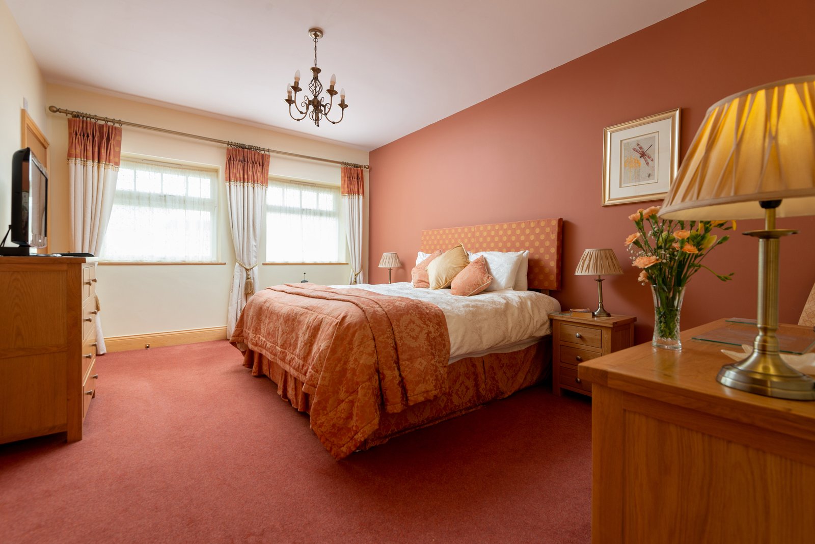 Cosy bedroom with orange accents and floral decor.