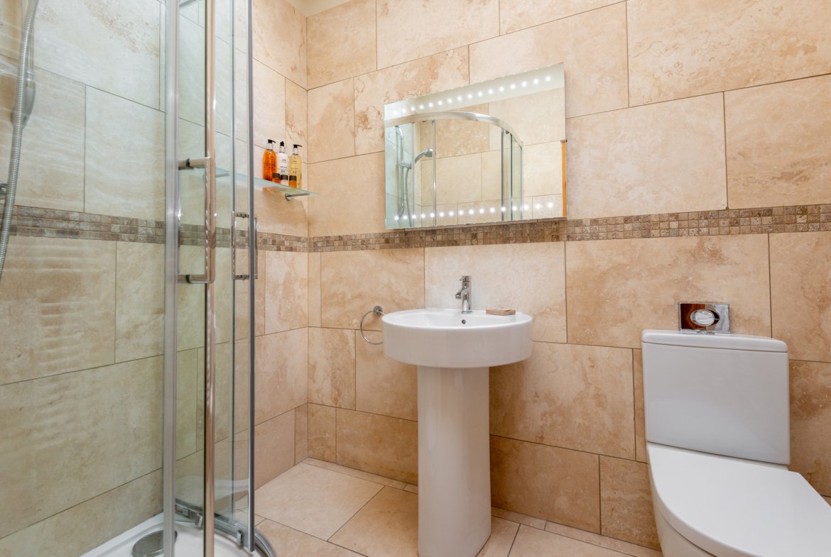 Modern bathroom with shower, sink, and toilet.
